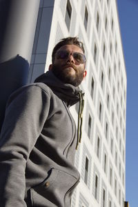 Low angle portrait of man in city against clear sky