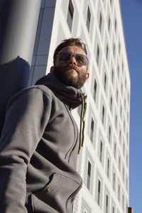 Low angle view of man standing against building in city