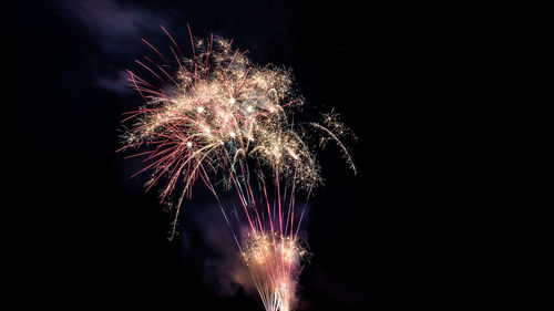 Low angle view of firework display at night