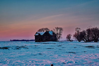 House by sea against sky during sunset