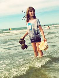 Happy girl standing on shore at beach