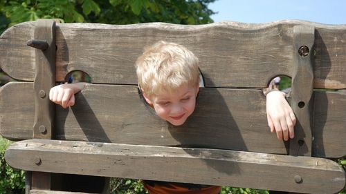 Portrait of cheerful boy trapped in pillory