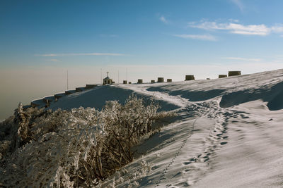 Snow covered field against sky