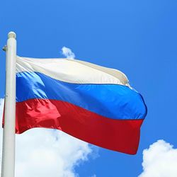 Low angle view of flag against blue sky