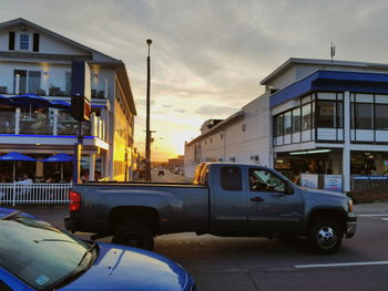 Cars on street in city against sky