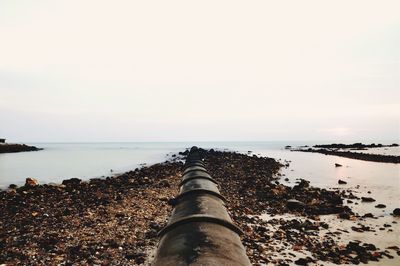 Scenic view of sea against sky with pipeline as a leading line