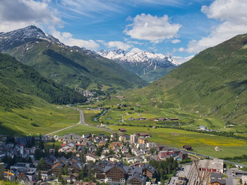 Scenic view of townscape and mountains against sky