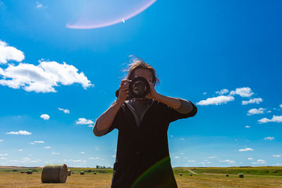 Woman standing on field against sky