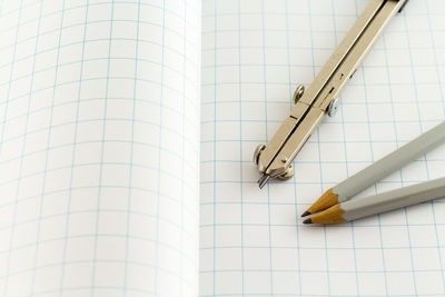 Close-up of pencils and dividers on open book