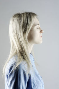 Portrait of young woman against white background