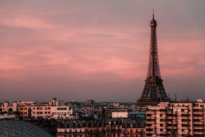 Eiffel tower amidst buildings against sky during sunset