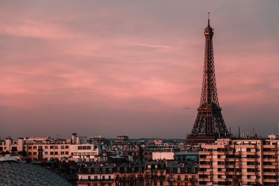 Eiffel tower amidst buildings against sky during sunset