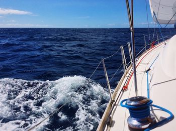 Boat sailing in sea against blue sky