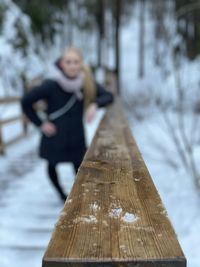 Full length of woman standing on snow covered tree during winter
