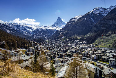 Aerial view of townscape and mountains against sky