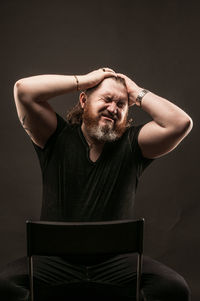 Portrait of young man against black background