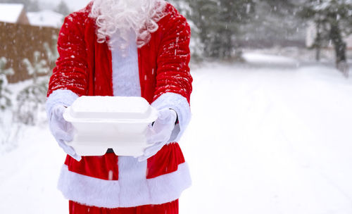 Midsection of woman holding snow