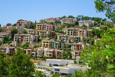 Buildings in city against clear blue sky