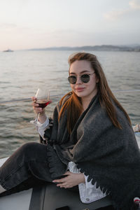 Portrait of smiling young woman sitting at beach