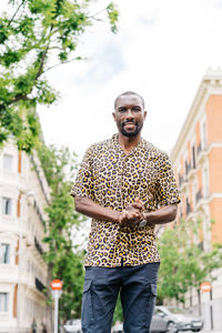 Positive afro american stylish man in european city looking at camera