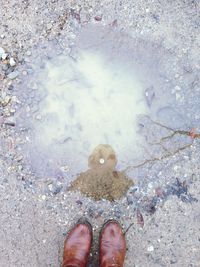 Low section of person standing in puddle