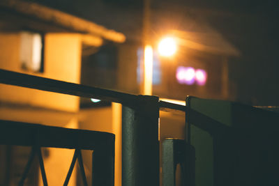 Close-up of illuminated railing against sky during sunset