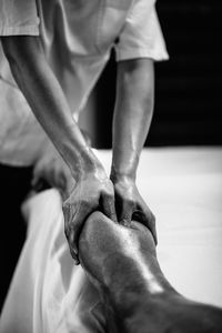 Woman massaging man lying on bed