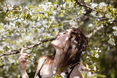 Close-up of young woman by flowering tree