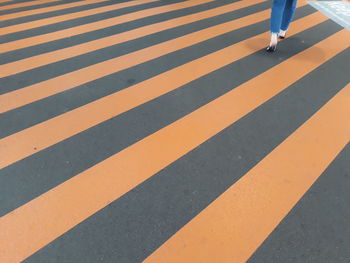 Low section of person walking on zebra crossing