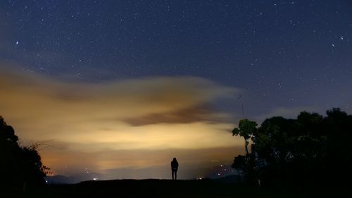 Silhouette of person against star field at night