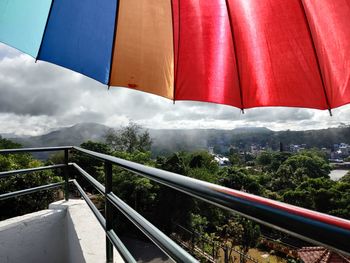 Red umbrella on staircase in city against sky