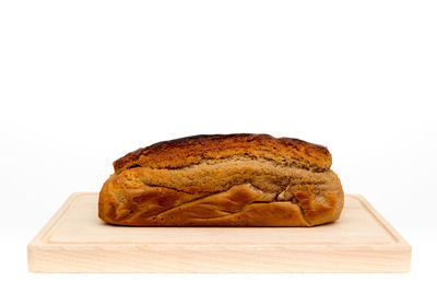 Close-up of bread on cutting board against white background