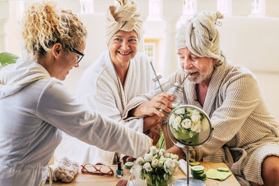 Smiling senior parents with daughter enjoying at home