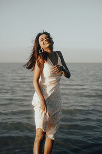 Young woman standing at beach