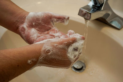 Close-up of hand holding faucet