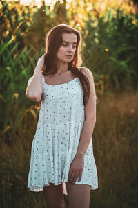 Young woman standing against plants