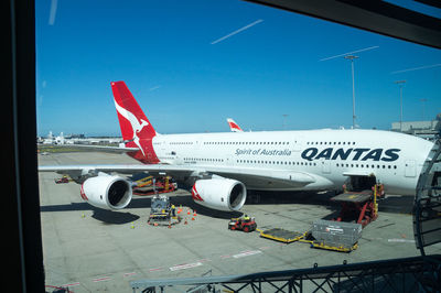 Airplane on airport runway against blue sky