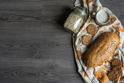 Top view of breakfast with bread, milk, cookies and oatmeal.