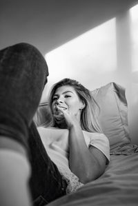 Portrait of woman sitting on bed at home
