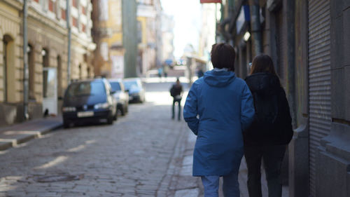 Rear view of two women walking on street of old town