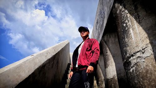 Young man standing against wall