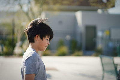 Side view portrait of boy standing outdoors