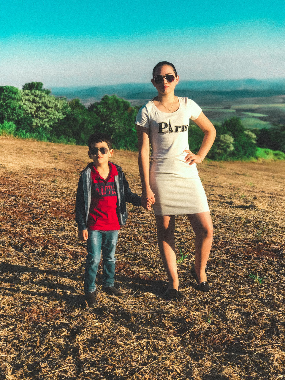 PORTRAIT OF YOUNG COUPLE STANDING ON FIELD