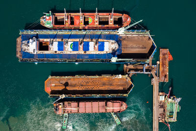 Aerial top view container oil ship in shipyard for repair and maintenance in green sea