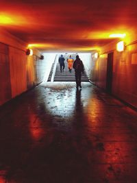 People walking in illuminated tunnel