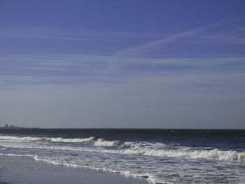 View of calm beach against blue sky