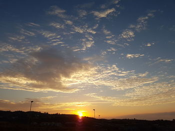 Scenic view of silhouette field against sky at sunset