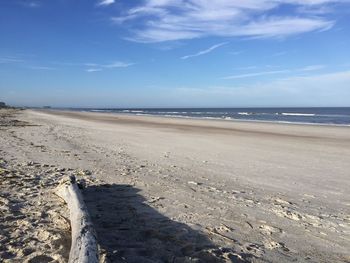 Scenic view of beach against blue sky