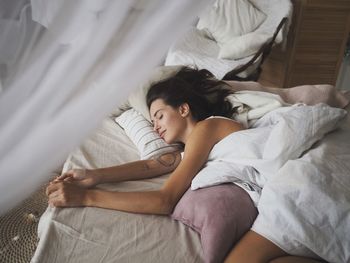 High angle view of man sleeping on bed