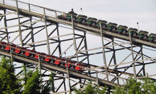 Low angle view of two roller coasters against sky